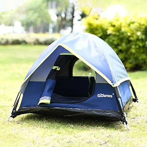 Blue dog tent set up outdoors on grass