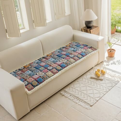 White sofa with a colorful patterned cover in a bright room.