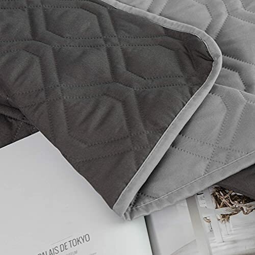 Gray quilted blanket on a magazine