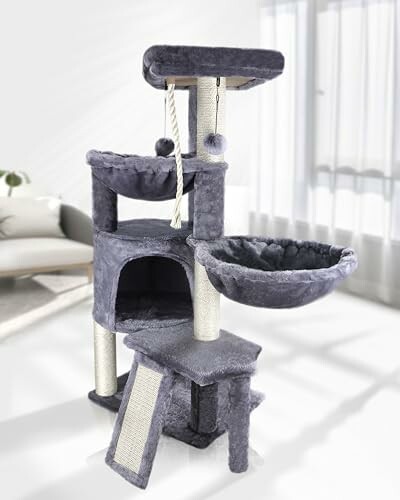 Multi-level grey cat tree with rope and platforms in a bright room.