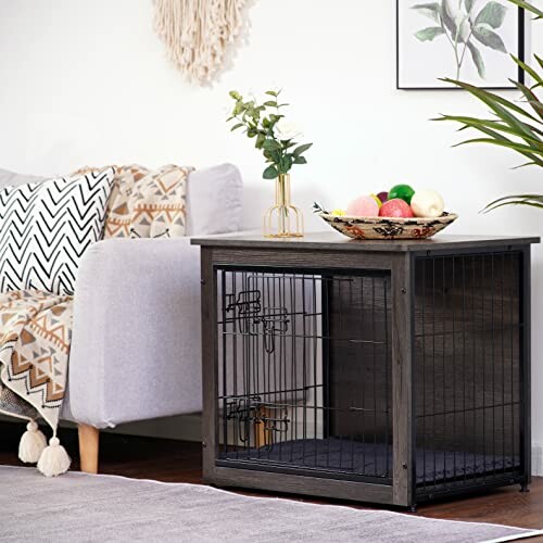 Stylish pet crate used as side table with decor and fruit bowl.